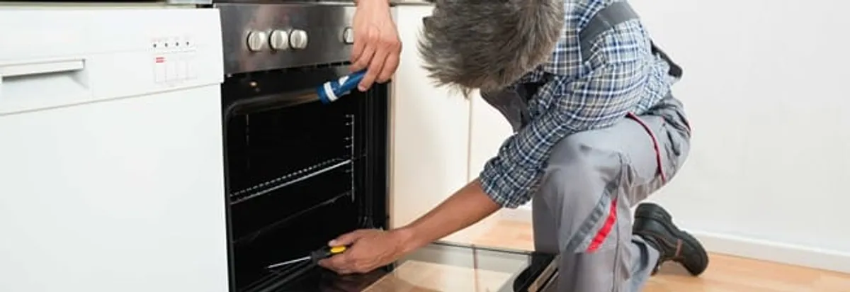 Oven repair technician inspecting and servicing an electric oven in Hialeah, FL