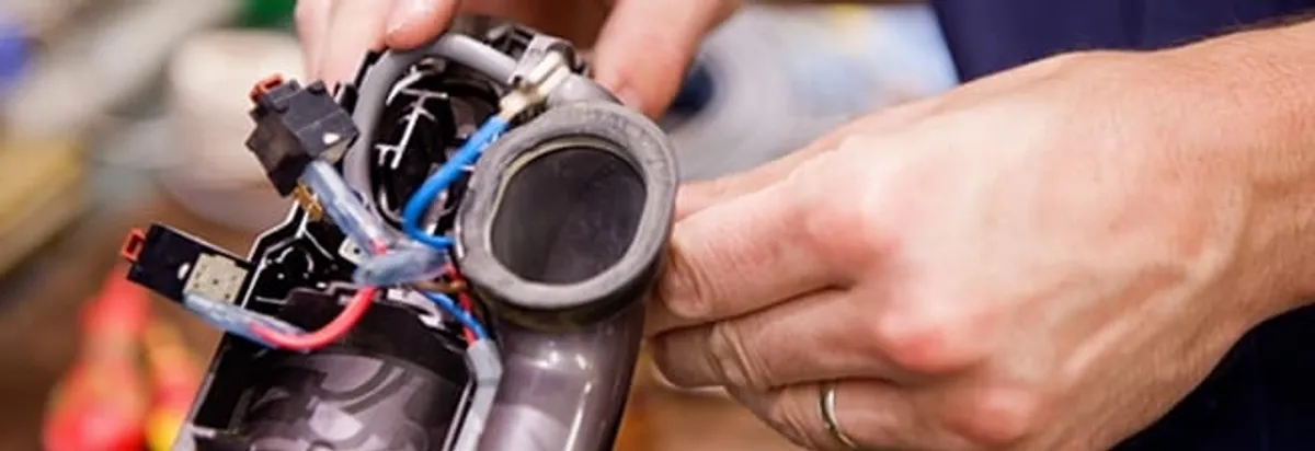 Vacuum repair technician reconnecting wiring and components in Hialeah, FL